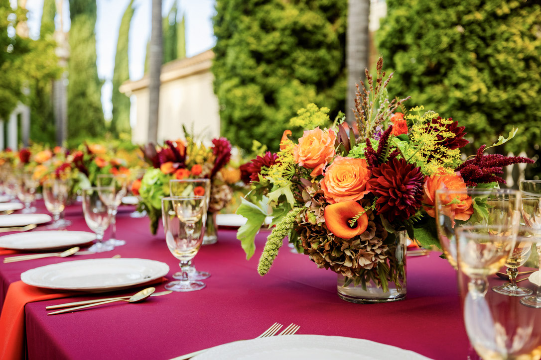 Colorful autumn floral centerpiece with burgundy linens